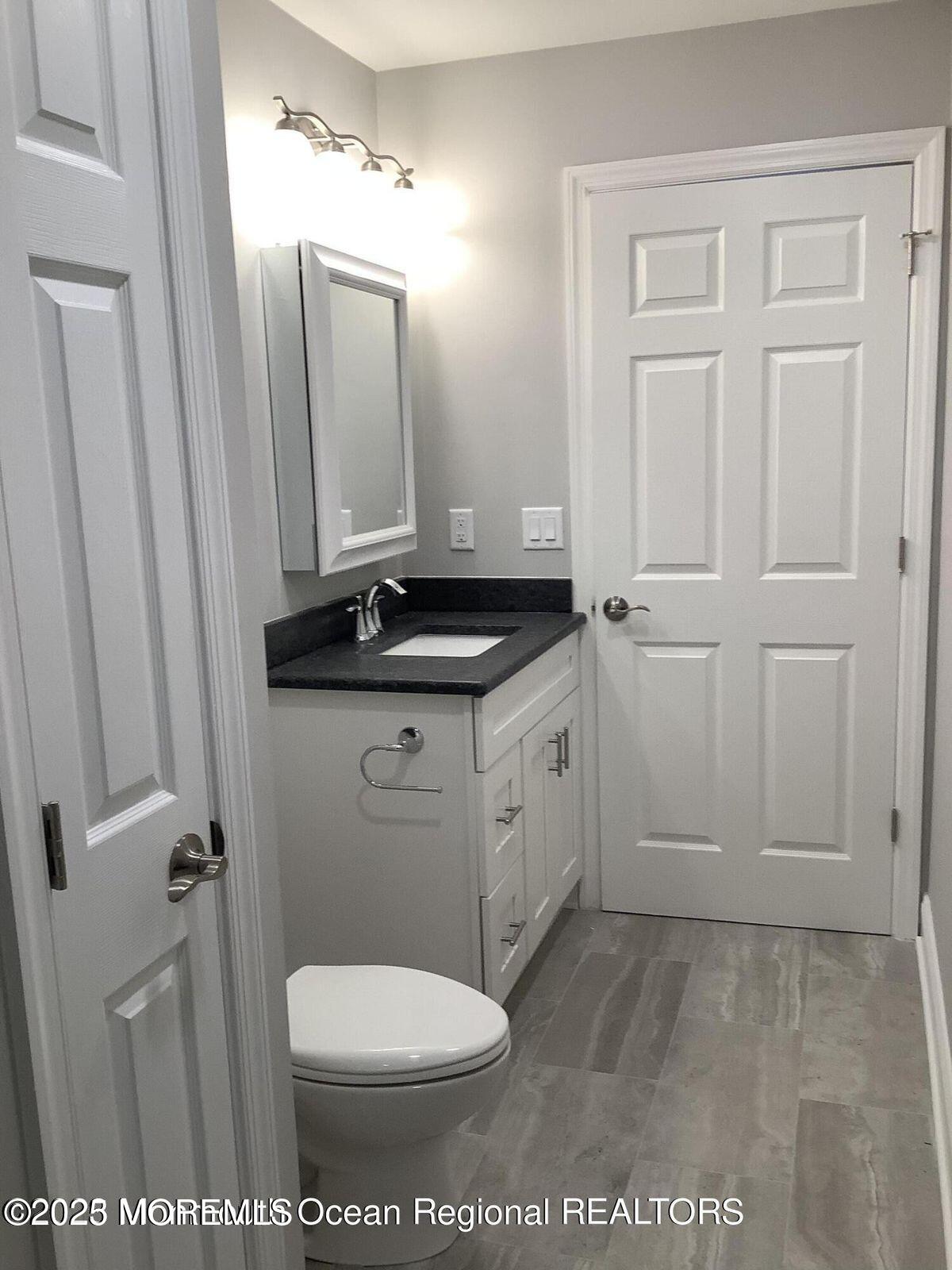 506 Harding Road, Unit 6 Freehold, NJ 07728 - Photo 14 of 21 a bathroom with a granite countertop sink toilet and mirror