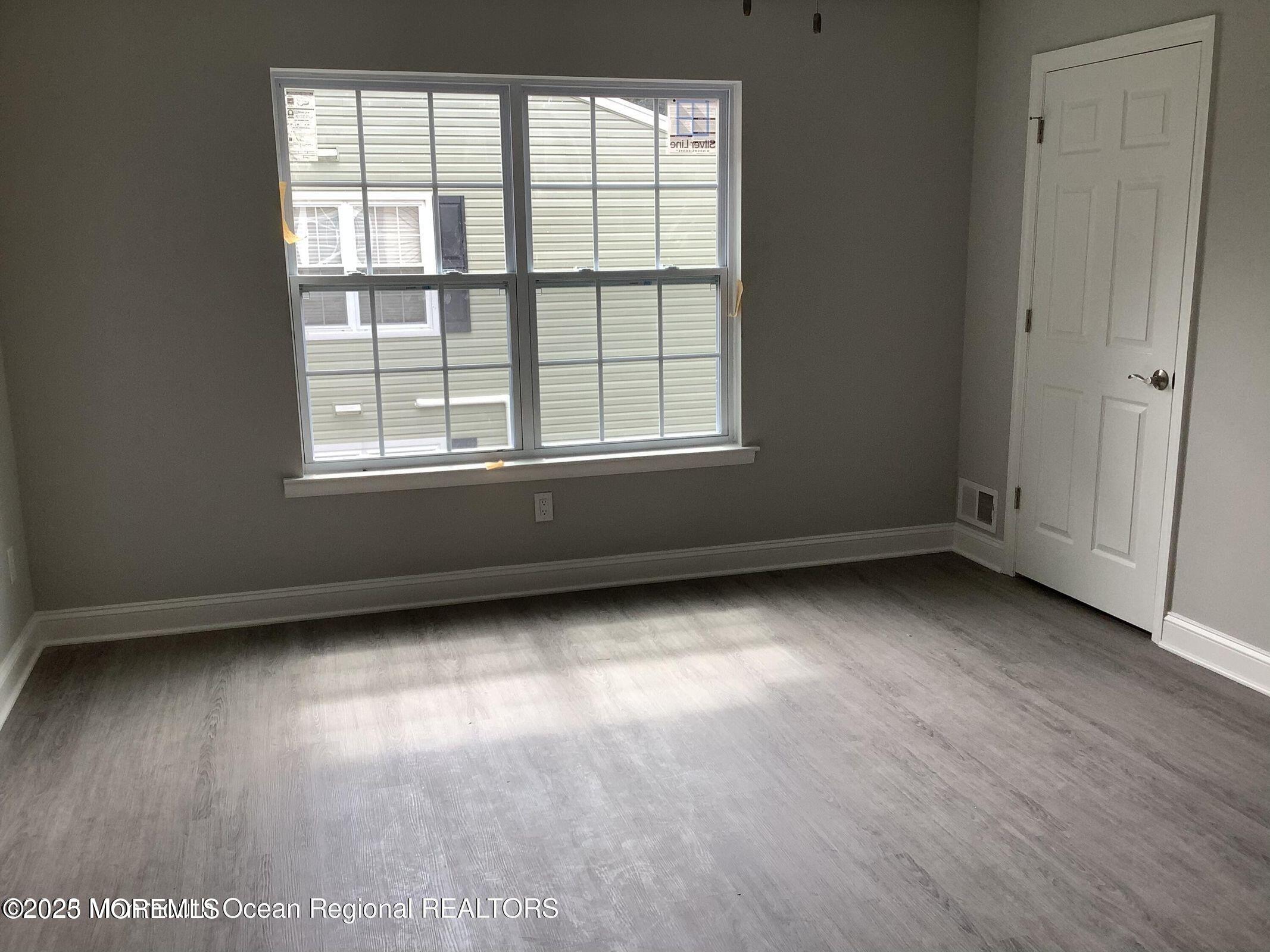 506 Harding Road, Unit 6 Freehold, NJ 07728 - Photo 18 of 21 an empty room with wooden floor and windows