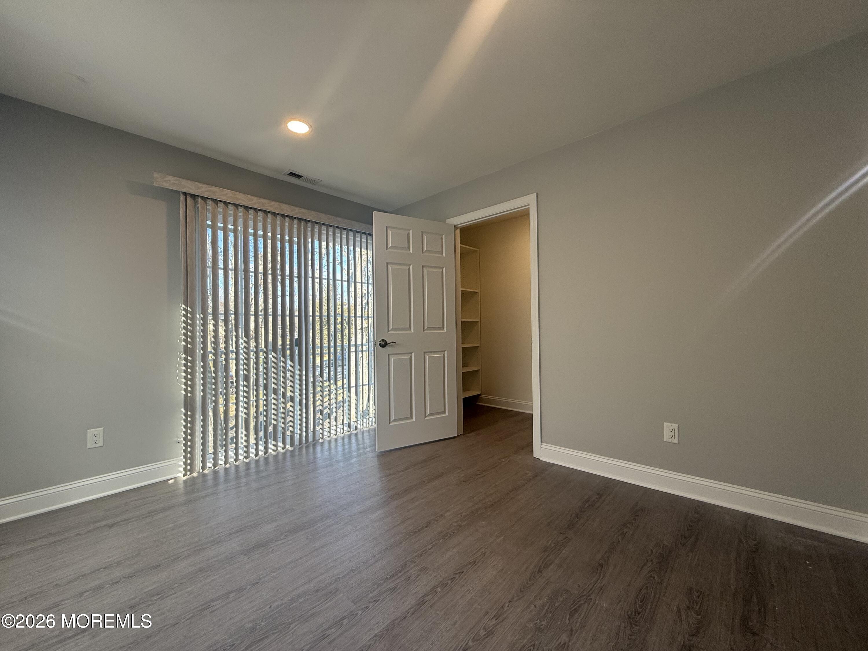 506 Harding Road, Unit 6 Freehold, NJ 07728 - Photo 20 of 31 a view of an empty room with wooden floor and a window