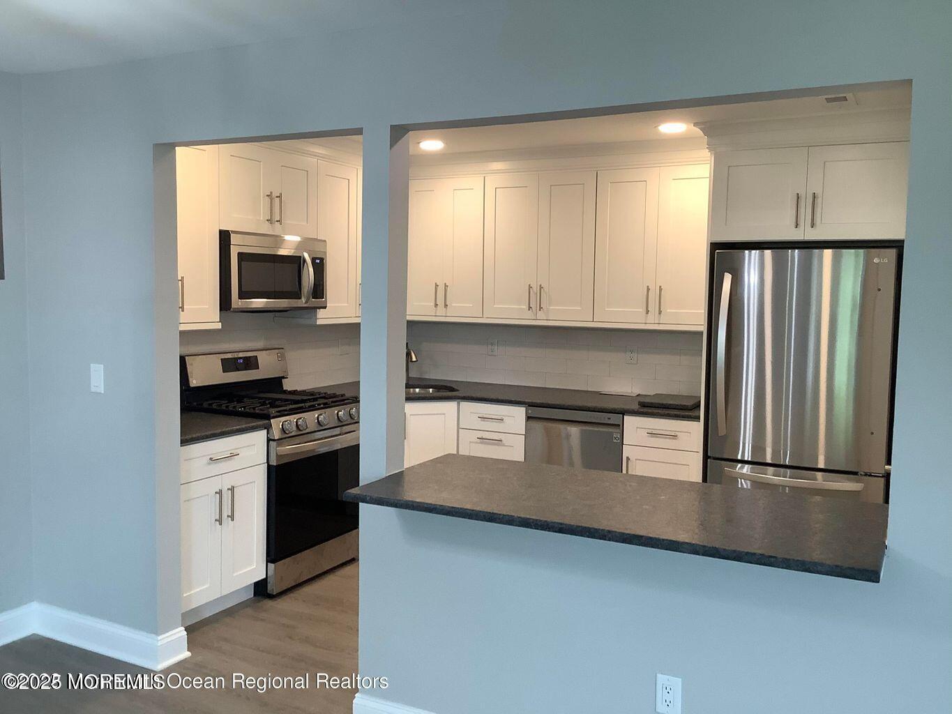 506 Harding Road, Unit 6 Freehold, NJ 07728 - Photo 2 of 21 a kitchen with granite countertop a refrigerator and a stove top oven