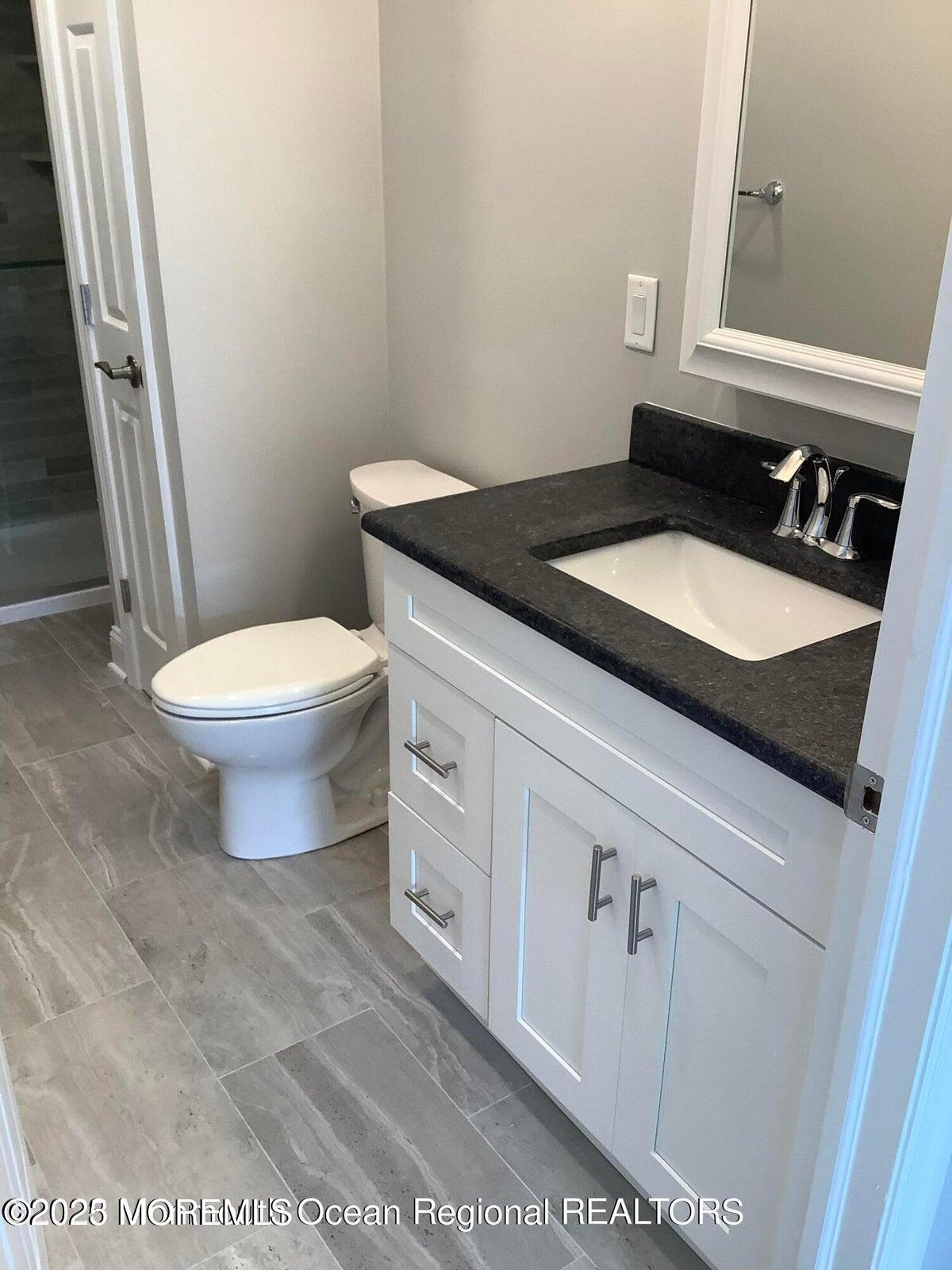 506 Harding Road, Unit 6 Freehold, NJ 07728 - Photo 23 of 31 a bathroom with a granite countertop toilet and sink