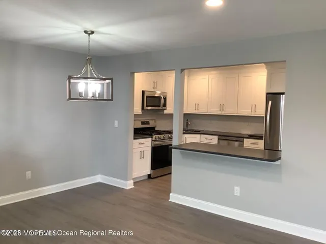 a kitchen with a refrigerator and a stove top oven