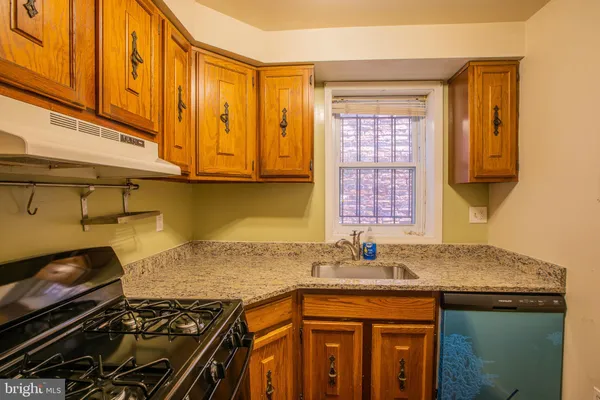 a kitchen with granite countertop a stove and a sink