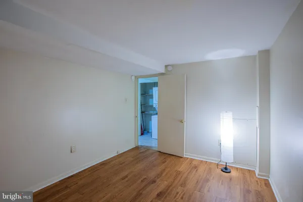 a view of an empty room with wooden floor and closet
