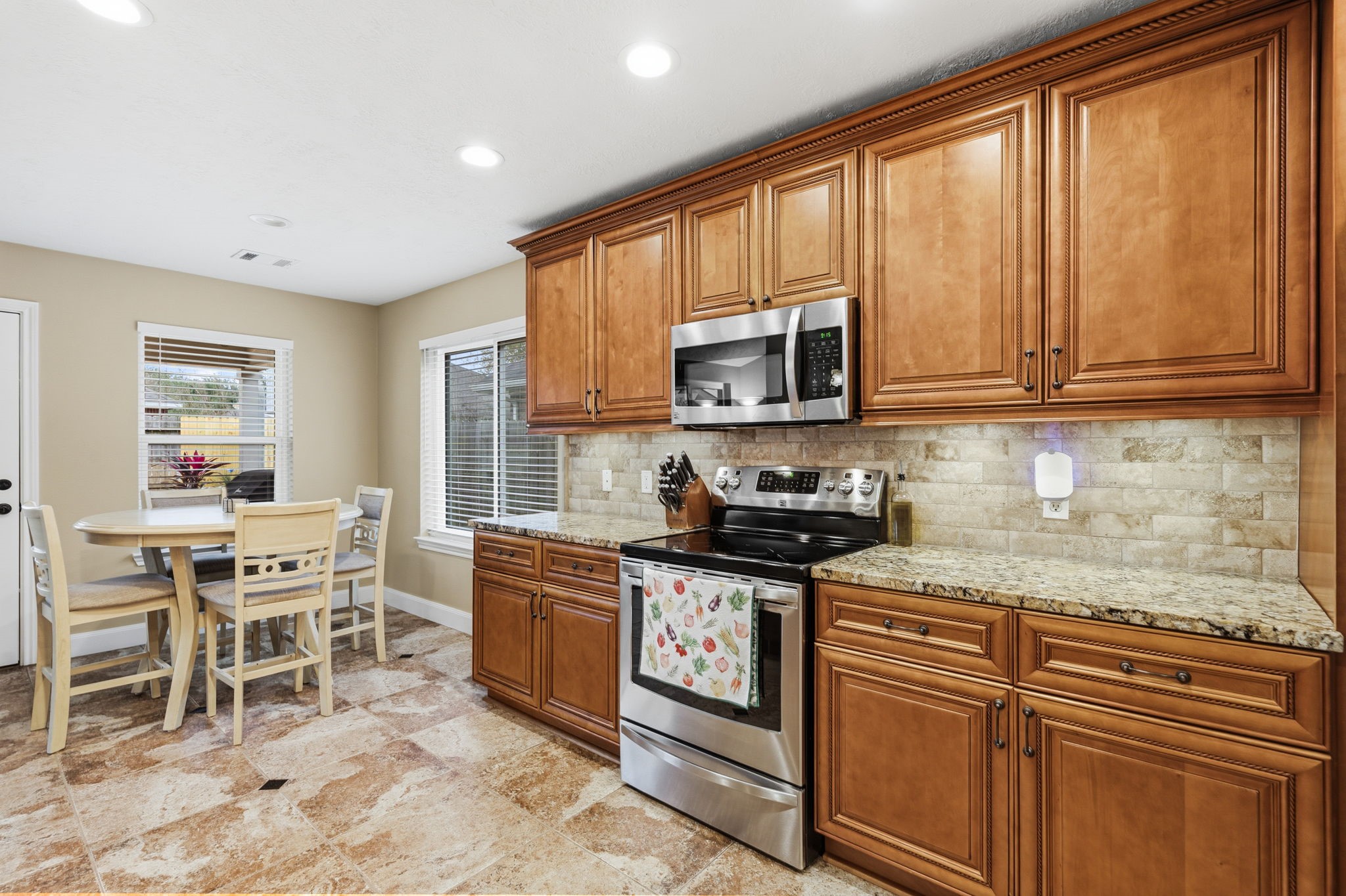 15319 Court Green Trail Cypress, TX 77433 - Photo 13 of 44 a kitchen with stainless steel appliances granite countertop wooden cabinets a stove top oven a sink and a granite counter tops