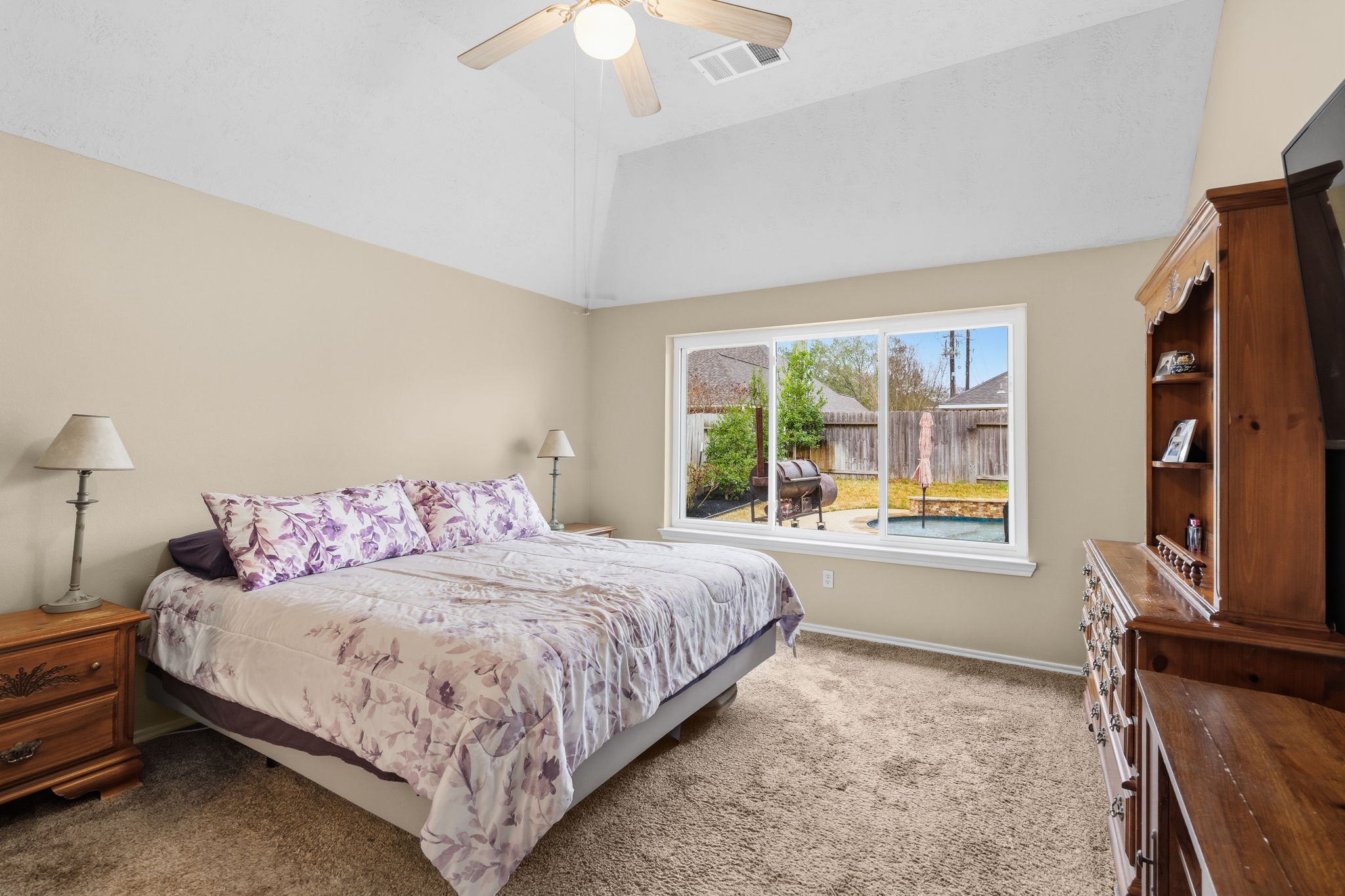 15319 Court Green Trail Cypress, TX 77433 - Photo 18 of 44 a bedroom with a bed and a flat tv screen on dresser