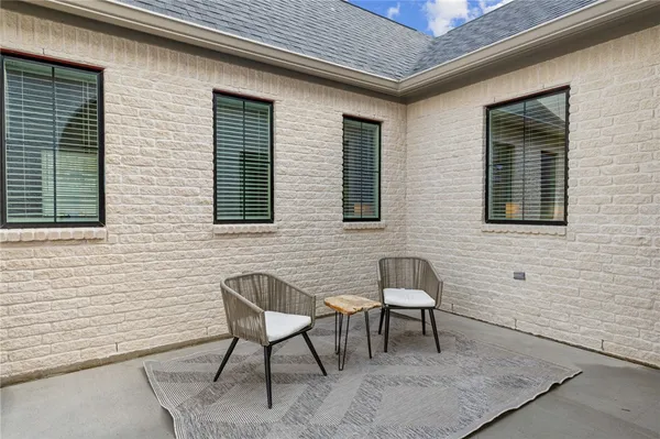 a brick house with table and chairs in front of it