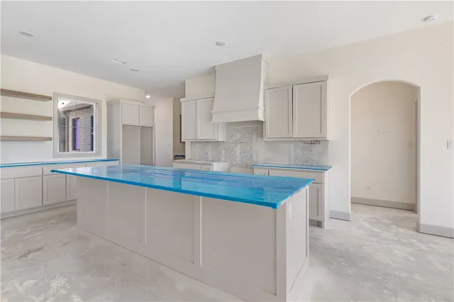 a kitchen with granite countertop a sink a stove and cabinets
