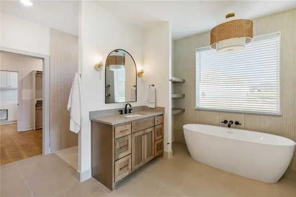 a bathroom with a double vanity sink mirror and bathtub