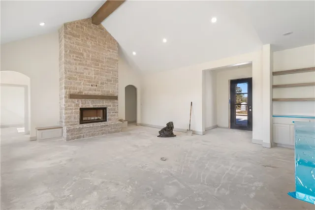 an empty room with fireplace and window