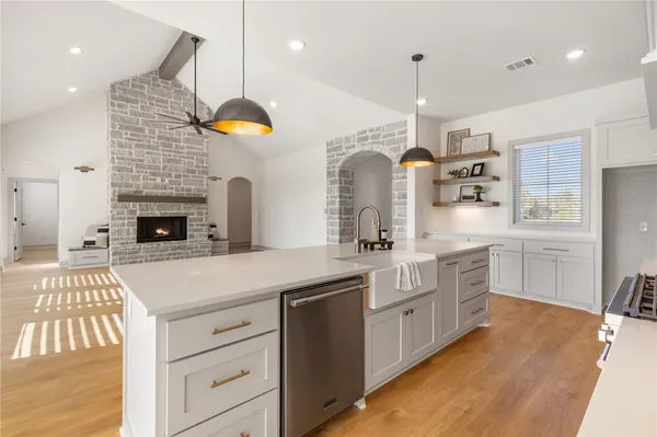 a kitchen with stainless steel appliances kitchen island granite countertop a stove a sink and a refrigerator