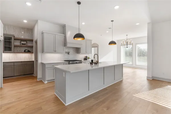 a large kitchen with stainless steel appliances kitchen island granite countertop a sink a stove and a refrigerator