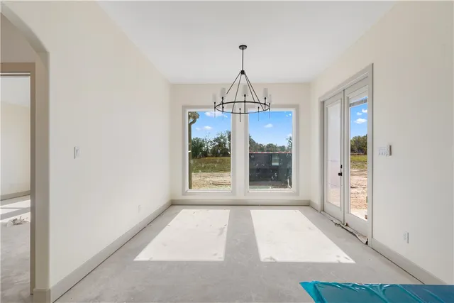 a view of hallway with a window and chandelier
