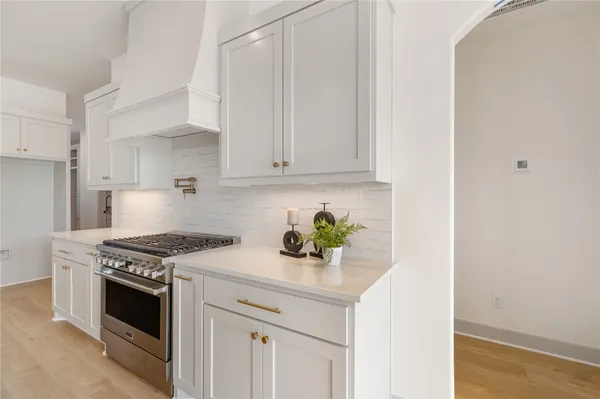 a kitchen with stainless steel appliances a stove a white cabinet and a granite counter tops