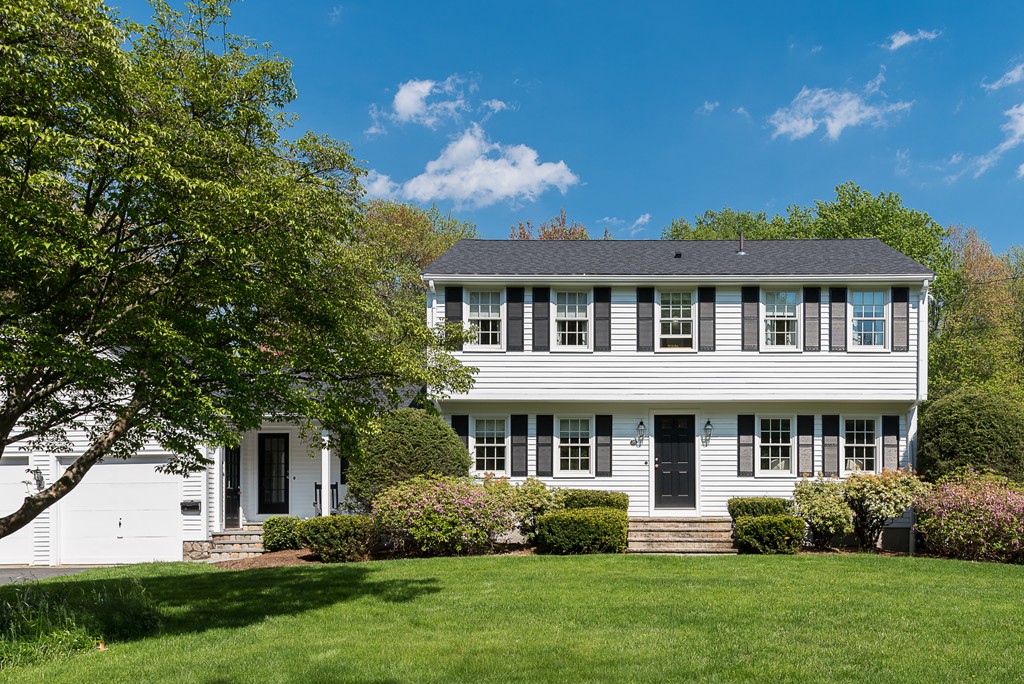 a front view of a house with a yard and potted plants