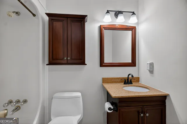 a bathroom with a toilet a sink and mirror