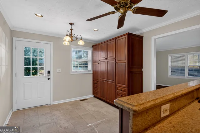 a view of kitchen with stainless steel appliances granite countertop cabinets and a chandelier