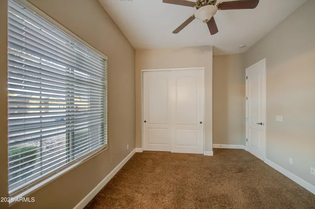 a view of a livingroom with a ceiling fan and window