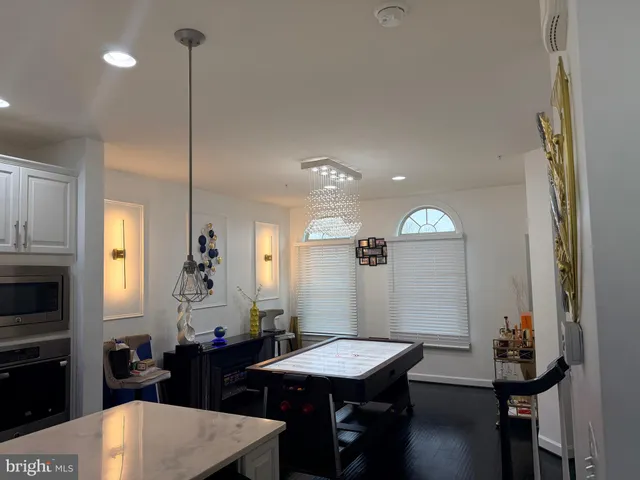 a kitchen with stainless steel appliances granite countertop a stove a refrigerator a sink dining table and chairs