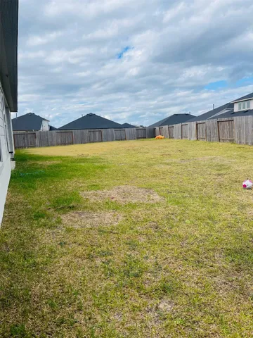 a view of swimming pool with lawn chairs and large trees