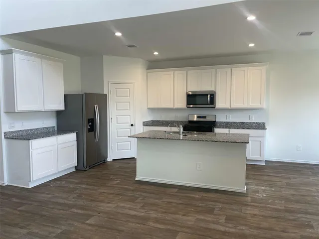 a kitchen with a refrigerator and a stove top oven