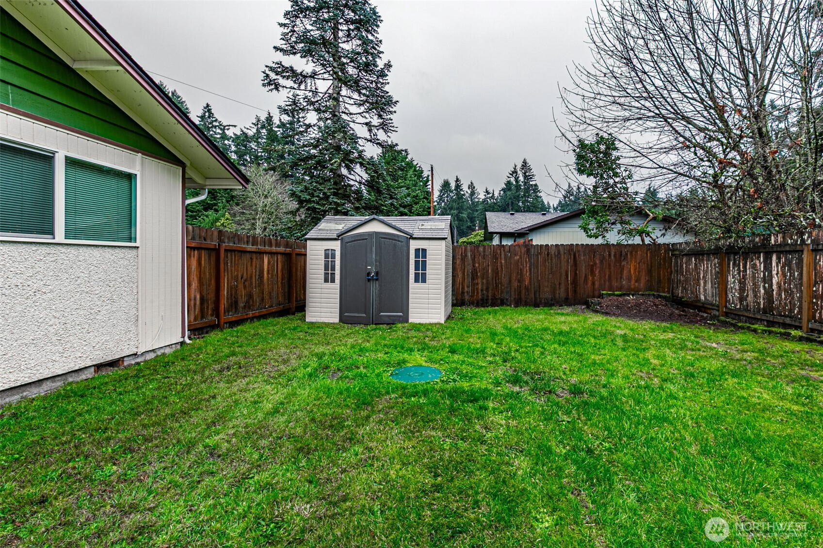 7505 Husky Way Southeast Lacey, WA 98503 - Photo 39 of 40 a view of a backyard with large trees and wooden fence