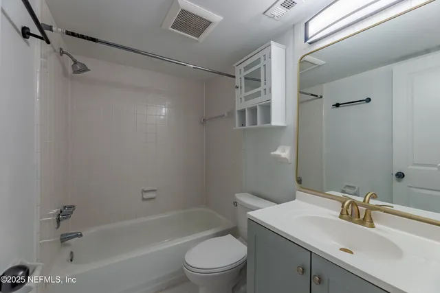 an empty room with wooden floor and a ceiling fan