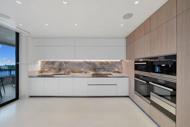 a kitchen with granite countertop white cabinets and stainless steel appliances