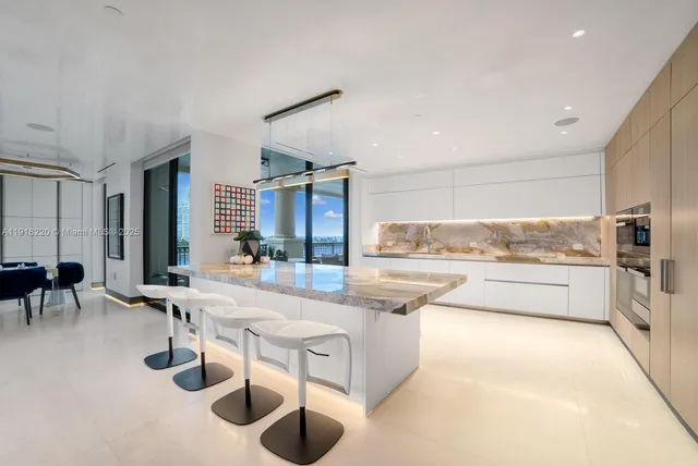 a large white kitchen with sink and furniture