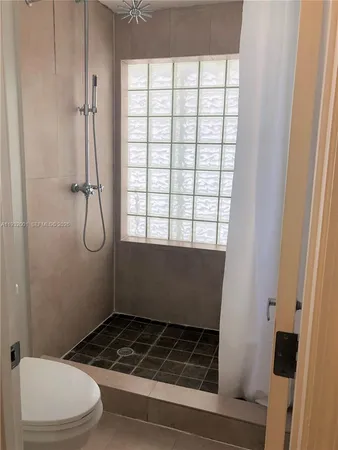 a bathroom with a toilet and a shower