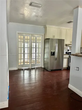 a view of a kitchen with refrigerator and wooden floor