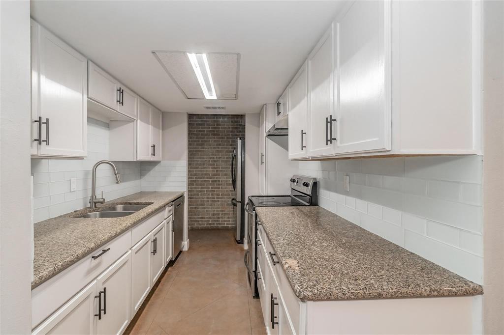 4930 Thunder Road Dallas, TX 75244 - Photo 15 of 23 Galley kitchen featuring white cabinetry with dark hardware, stone-finish countertops, subway tile backsplash, and stainless steel appliances