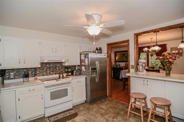 4 Belknap Road Hudson, NH 03051 - Photo 8 of 30 a kitchen with white cabinets and stainless steel appliances