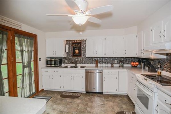4 Belknap Road Hudson, NH 03051 - Photo 10 of 30 a kitchen with white cabinets and white appliances