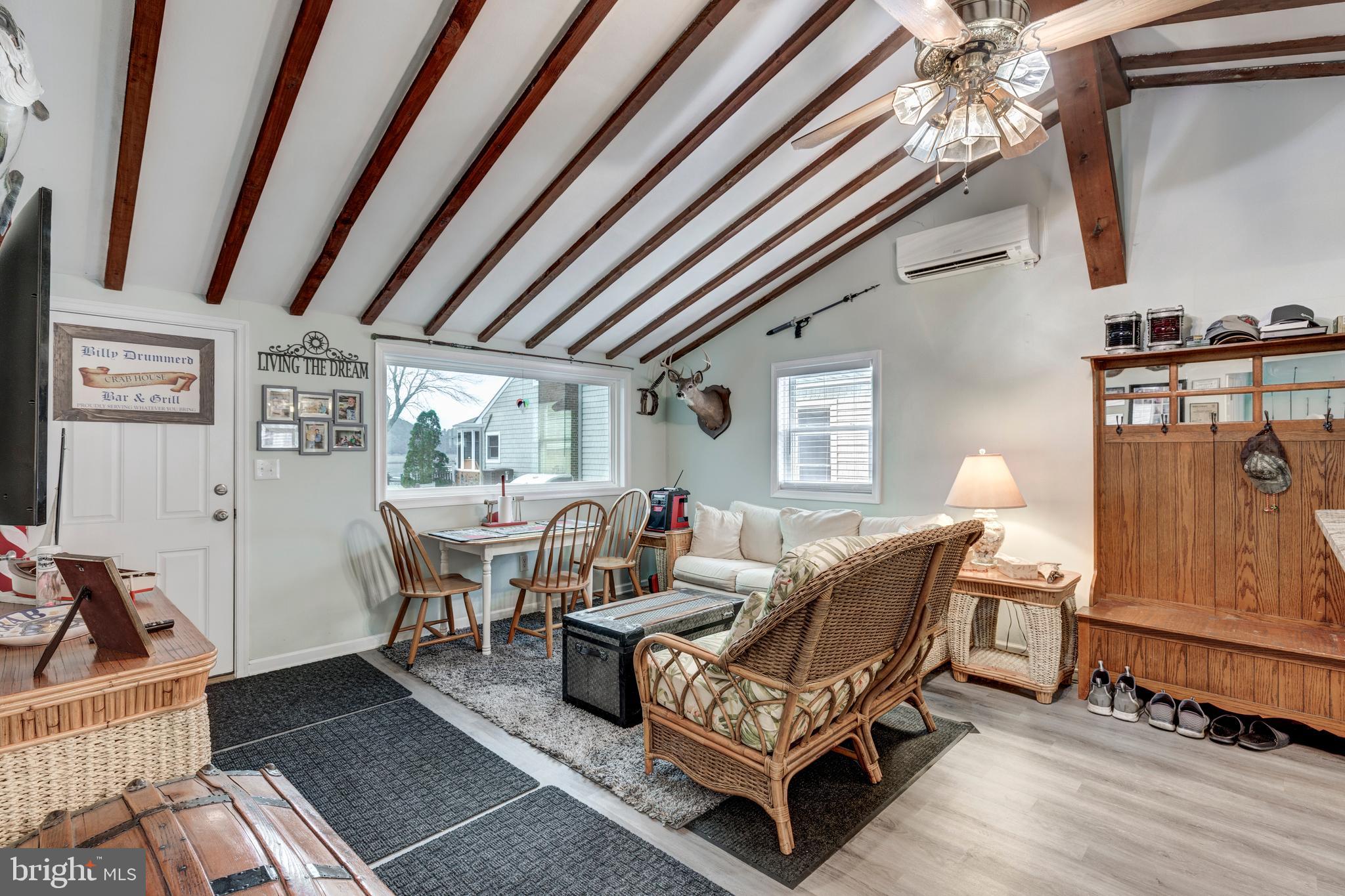 648 Chester River Beach Road Grasonville, MD 21638 - Photo 17 of 62 a living room with furniture a couch and paintings on the wall