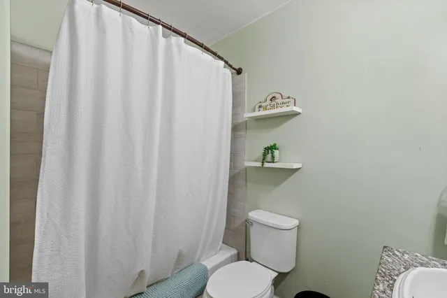 a bathroom with a toilet and a shower curtain