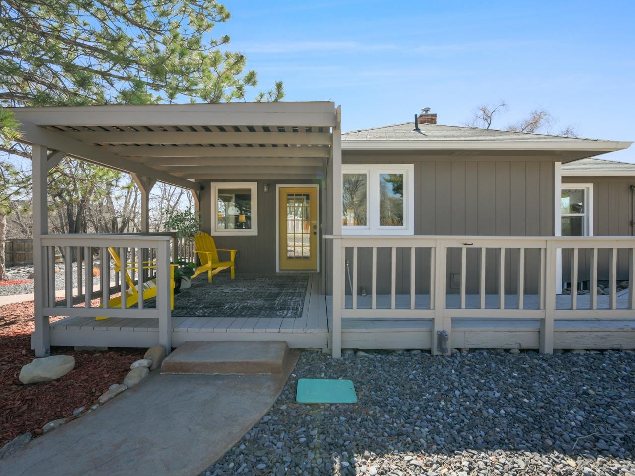 a view of a house with a small yard and wooden floor and fence
