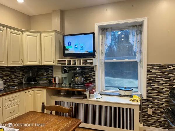 a room with water heater and wooden cabinets