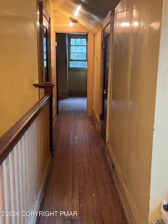 an empty room with windows and ceiling fan