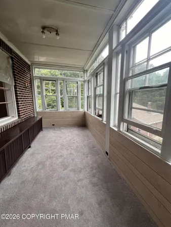 an empty room with windows and ceiling fan