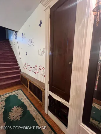 a big room with chandelier front door and windows