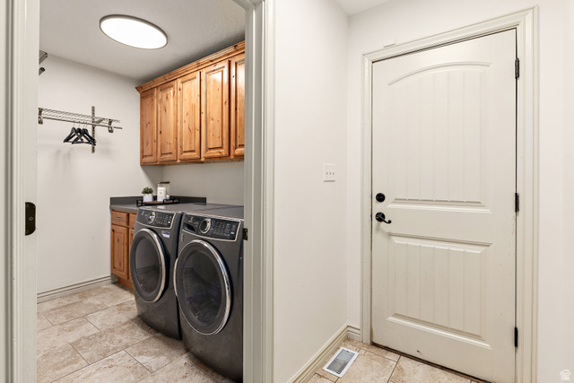 912 North Loafer Canyon Road Elk Ridge, UT 84651 - Photo 26 of 98 Laundry area featuring wood cabinetry, dark countertop, and tile flooring