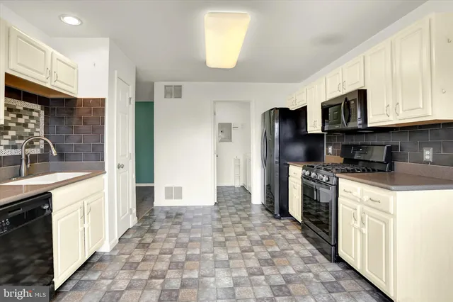 a kitchen with stainless steel appliances granite countertop a refrigerator stove top oven and sink