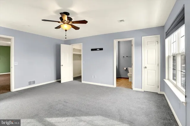 a view of a livingroom with a ceiling fan and window