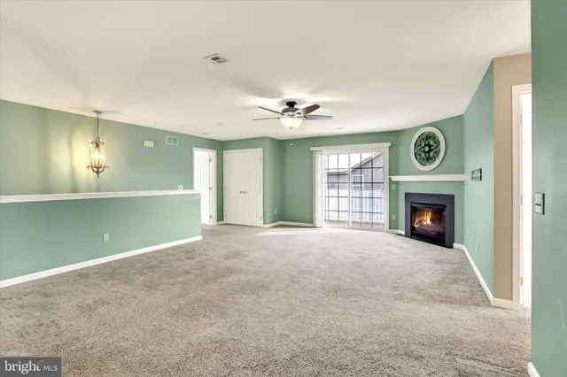 a view of an empty room with a fireplace and a window