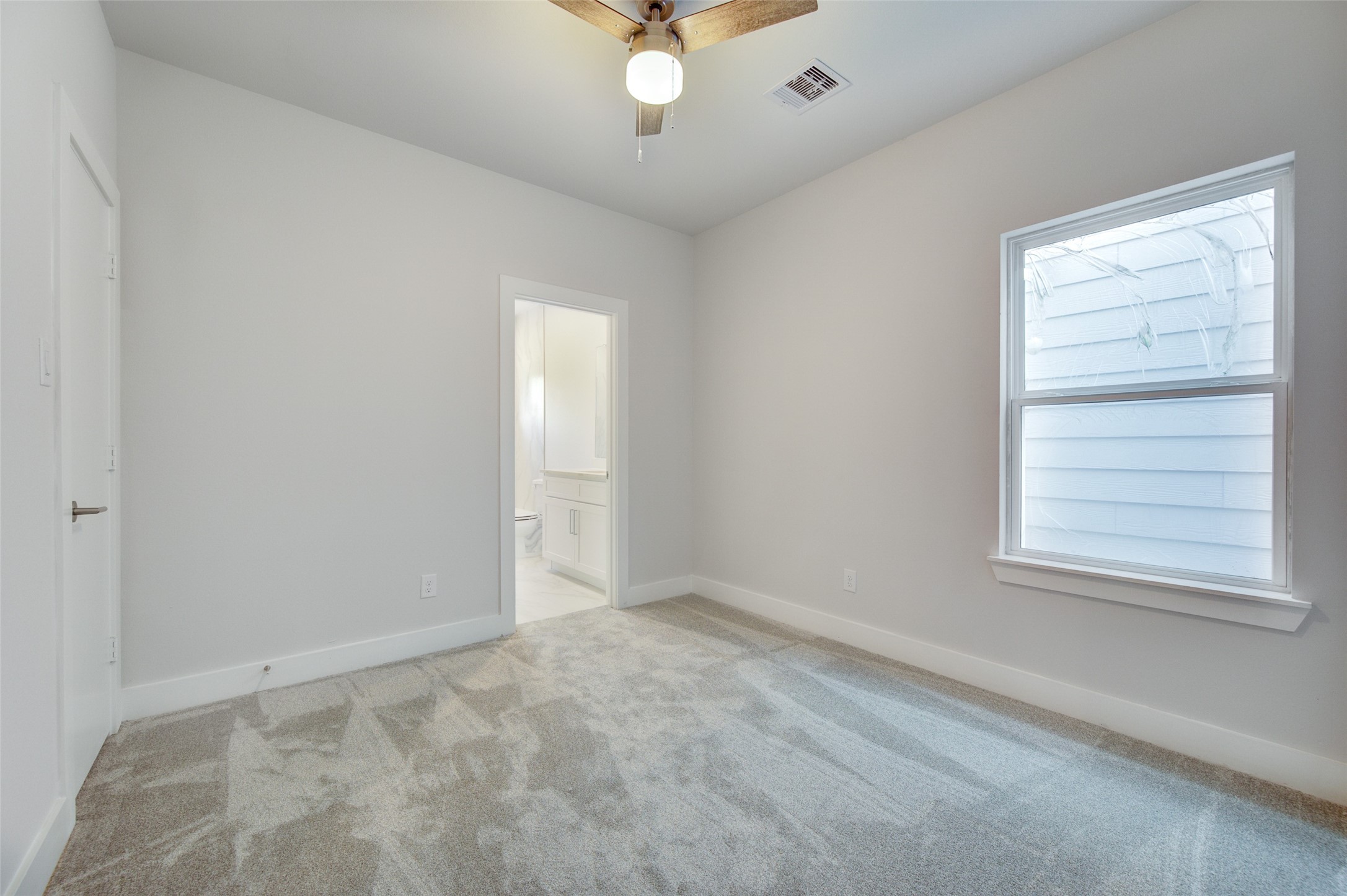 853 Mansfield Street, Unit F Houston, TX 77091 - Photo 11 of 18 an empty room with a window and a ceiling fan