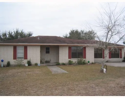 a front view of house with yard and trees around