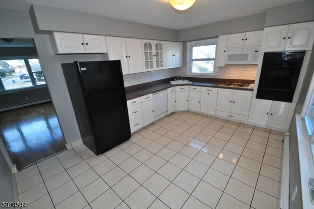 a kitchen with a sink a refrigerator and cabinets