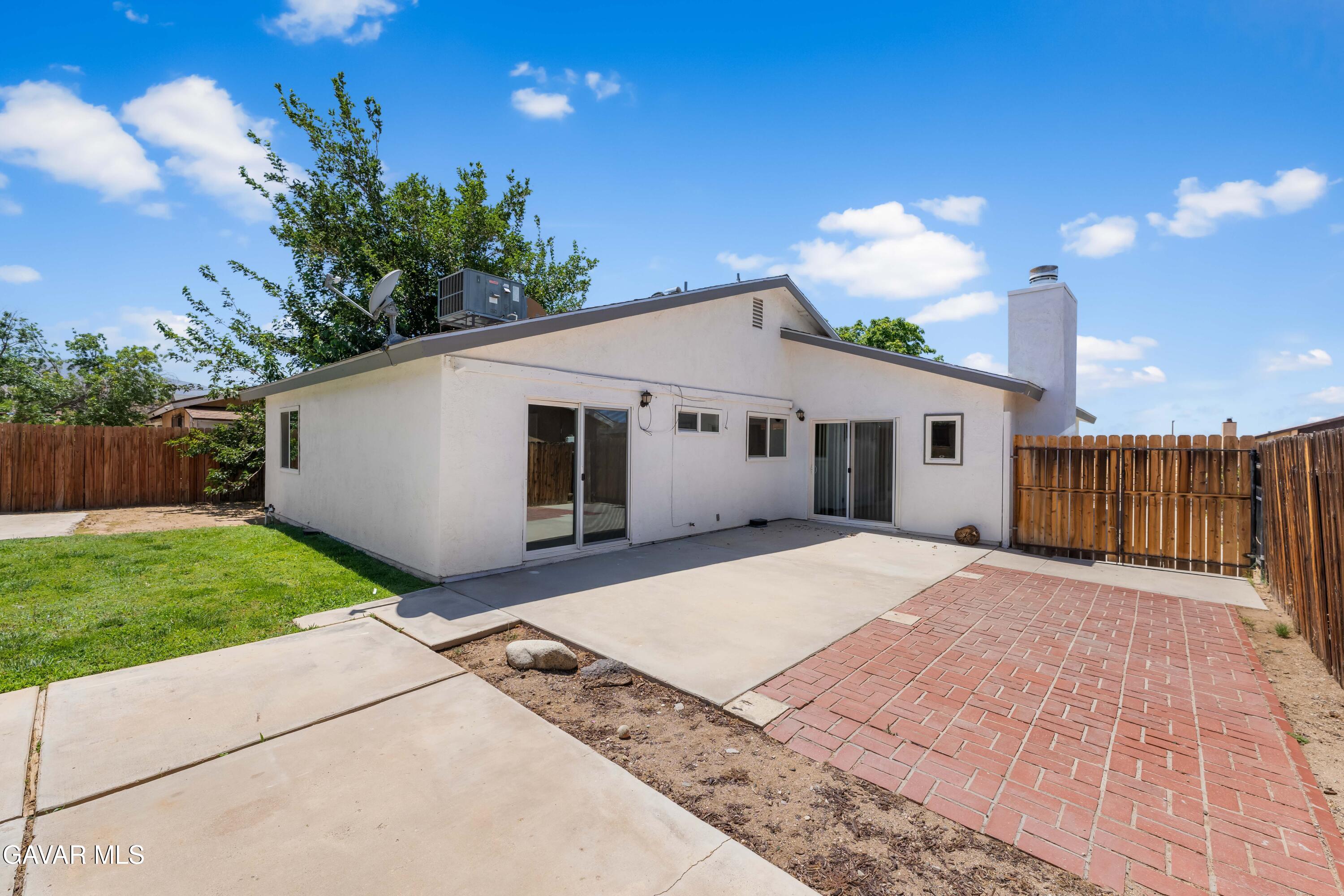 39056 Dianron Road Palmdale, CA 93551 - Photo 30 of 35 a view of a house with a yard and a garage