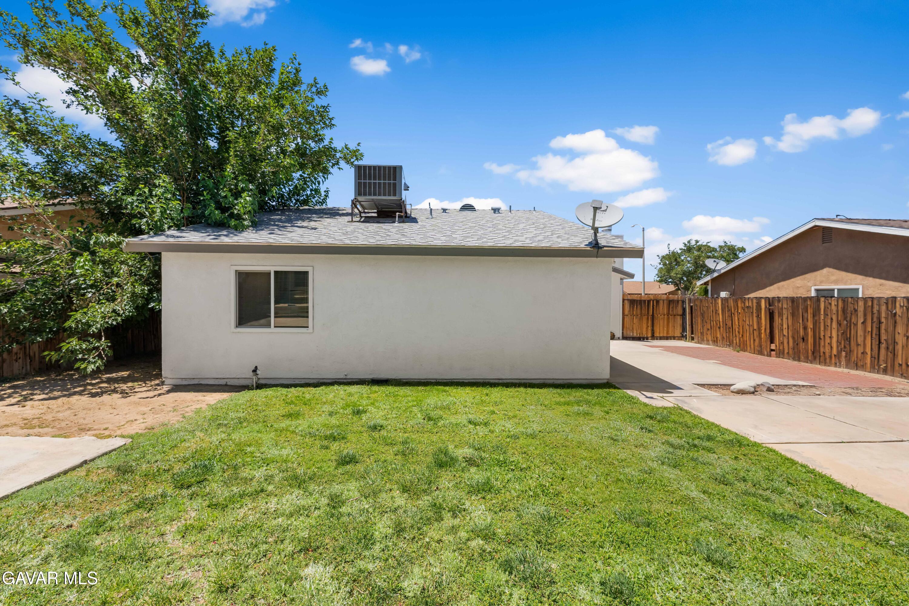 39056 Dianron Road Palmdale, CA 93551 - Photo 33 of 35 a view of a house with a backyard and a tree